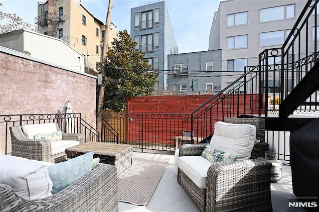 view of patio with stairway, outdoor lounge area, and fence