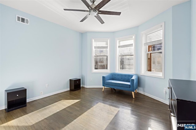 sitting room featuring dark wood-type flooring and ceiling fan