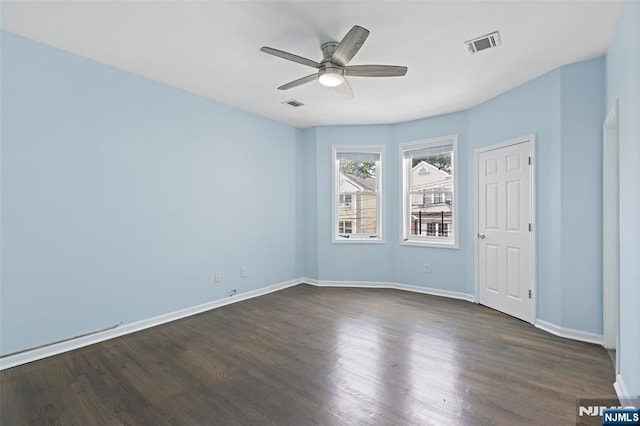 empty room featuring ceiling fan and dark hardwood / wood-style flooring