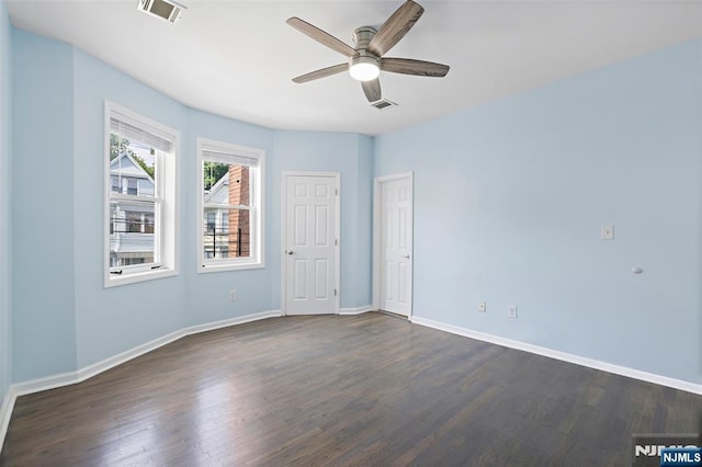 spare room with dark wood-type flooring and ceiling fan