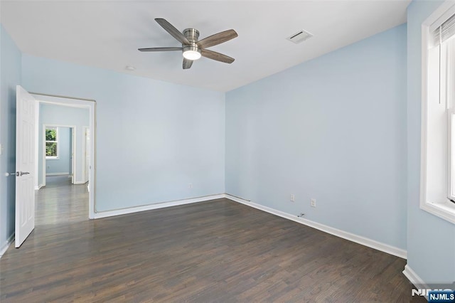 empty room with dark hardwood / wood-style floors and ceiling fan