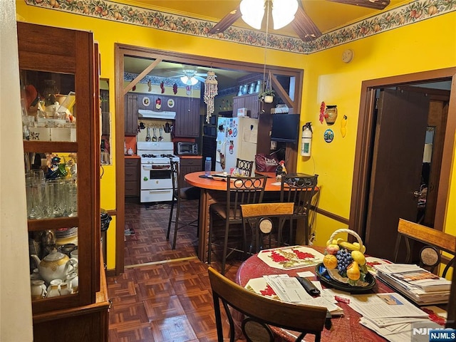 dining area with dark parquet flooring and ceiling fan