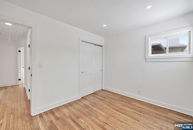 unfurnished bedroom with light wood-type flooring and a closet