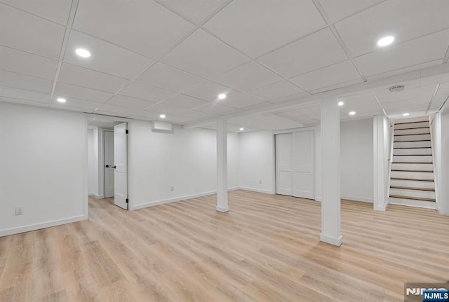 basement featuring a drop ceiling and light wood-type flooring