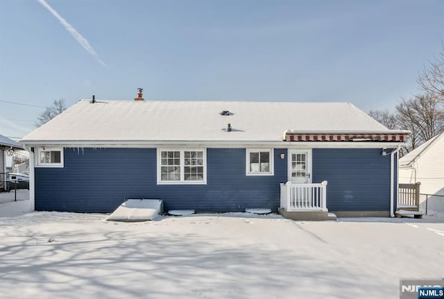 view of snow covered rear of property