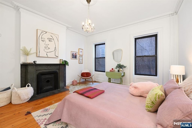 bedroom featuring an inviting chandelier, ornamental molding, and wood-type flooring