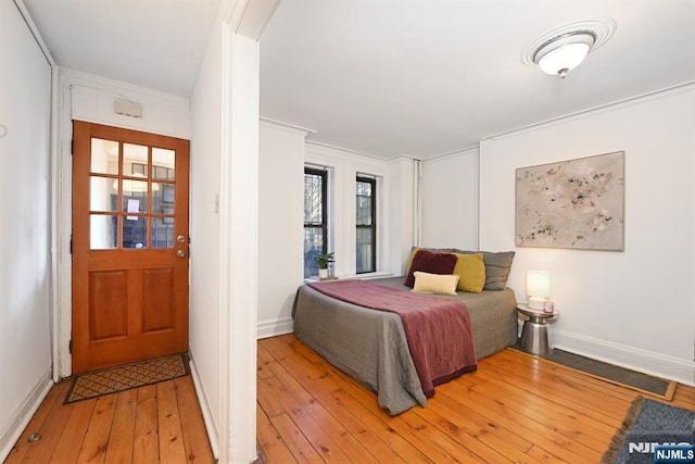 bedroom with crown molding and light hardwood / wood-style floors