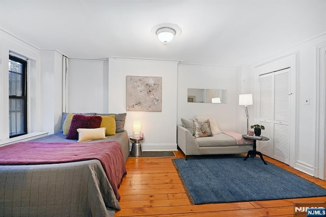 bedroom with wood-type flooring and a closet