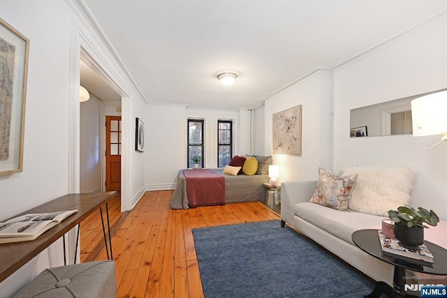 bedroom featuring crown molding and light hardwood / wood-style floors