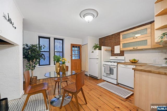 kitchen featuring wood counters, sink, white appliances, light hardwood / wood-style floors, and backsplash