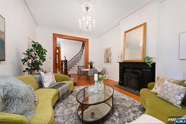 living room featuring ornamental molding, wood-type flooring, and a notable chandelier