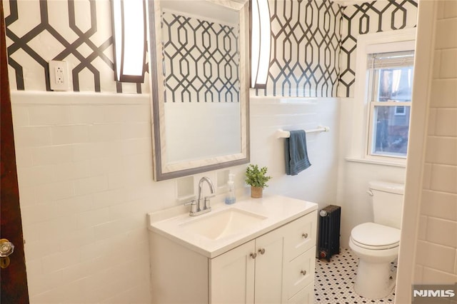 bathroom with vanity, radiator heating unit, and toilet