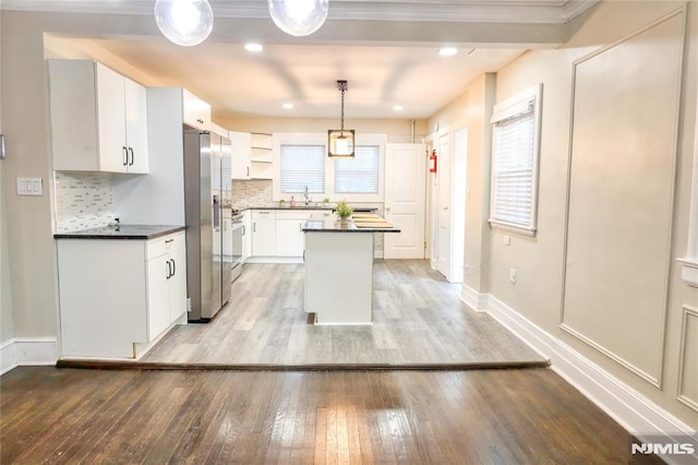 kitchen featuring a center island, stainless steel fridge with ice dispenser, hanging light fixtures, light wood-type flooring, and white cabinets