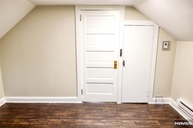 bonus room featuring dark hardwood / wood-style floors, vaulted ceiling, and a baseboard heating unit