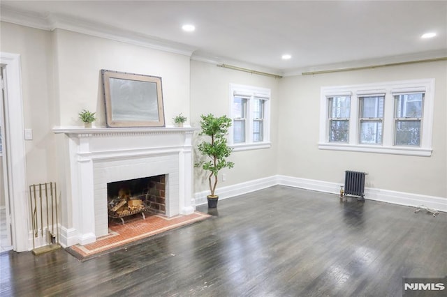 unfurnished living room with a fireplace, crown molding, radiator heating unit, and dark hardwood / wood-style floors