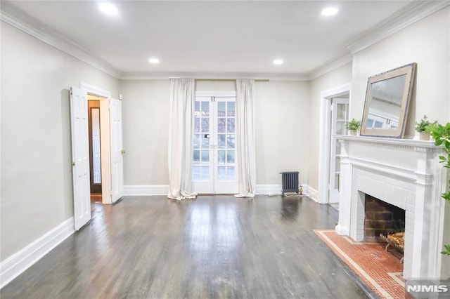 unfurnished living room featuring dark wood-type flooring, ornamental molding, radiator heating unit, and a fireplace