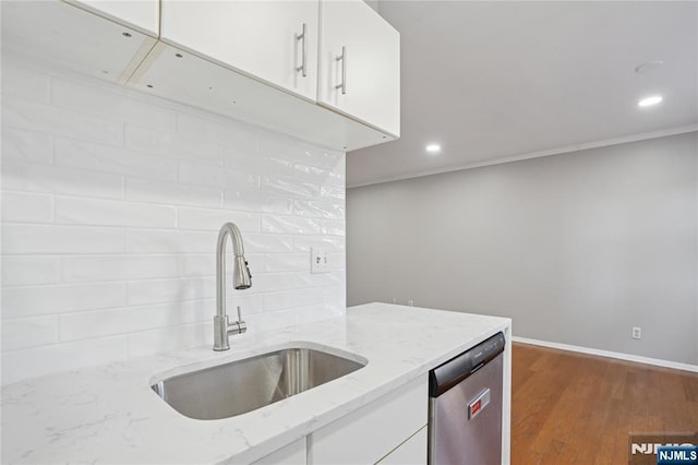 kitchen with light stone counters, dishwasher, tasteful backsplash, and white cabinets