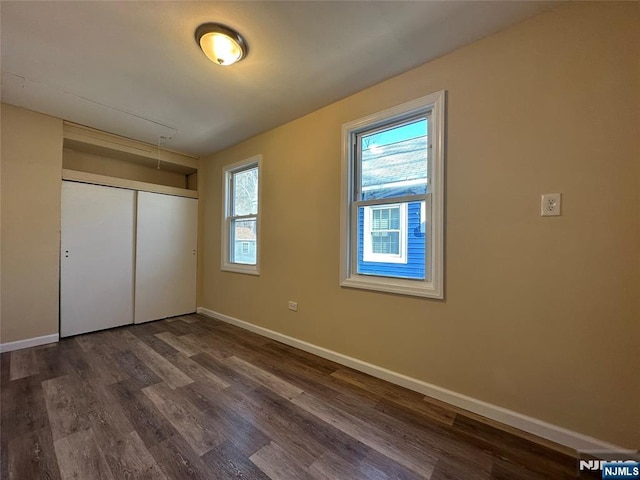 unfurnished bedroom featuring dark hardwood / wood-style flooring and a closet