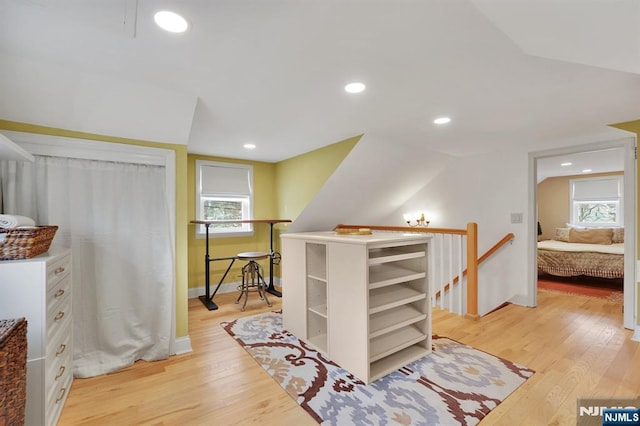 interior space with lofted ceiling and light hardwood / wood-style flooring