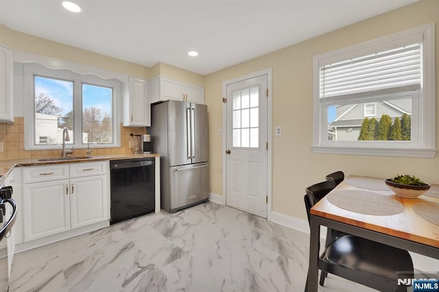 kitchen with sink, dishwasher, stone counters, white cabinetry, and high end refrigerator