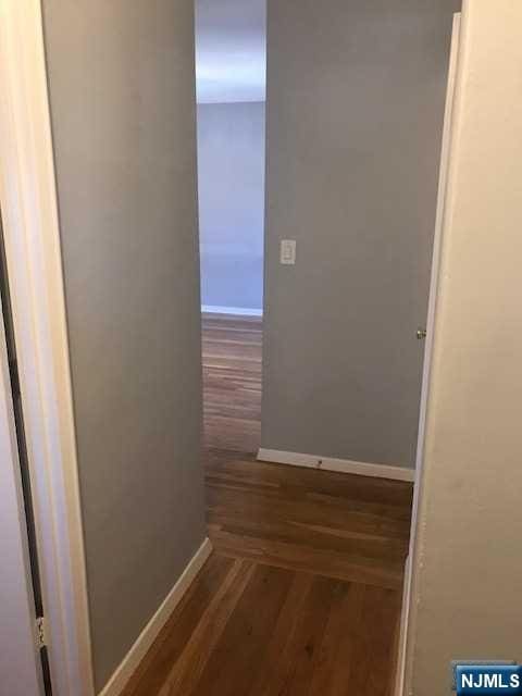 hallway with dark hardwood / wood-style floors