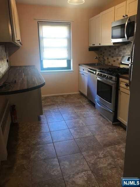 kitchen with white cabinetry, appliances with stainless steel finishes, sink, and decorative backsplash