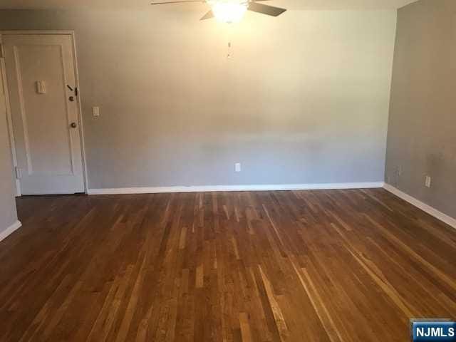 empty room featuring ceiling fan and dark hardwood / wood-style flooring