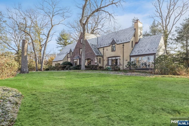 rear view of house featuring a yard