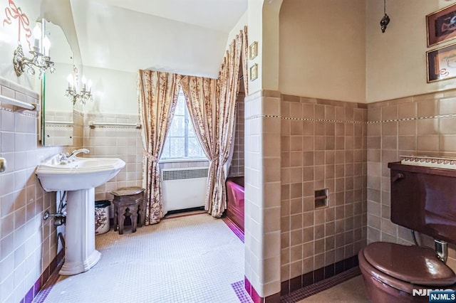 bathroom featuring shower / bathtub combination with curtain, toilet, radiator, and tile walls