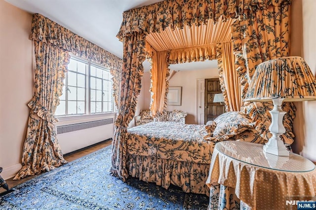 bedroom featuring hardwood / wood-style flooring and radiator