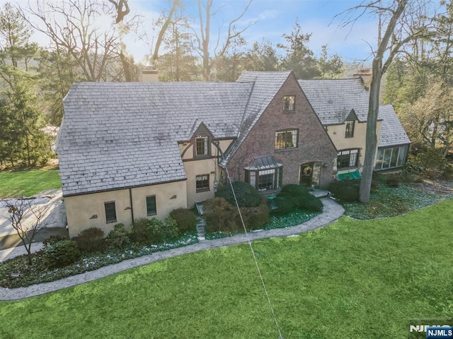 tudor home with a front lawn