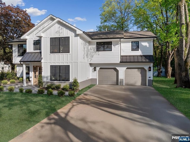 view of front of home featuring a standing seam roof, driveway, metal roof, a garage, and a front lawn