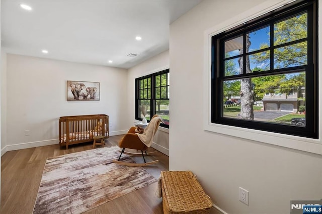 living area featuring baseboards, wood finished floors, and recessed lighting