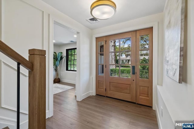 foyer entrance with wood finished floors and baseboards