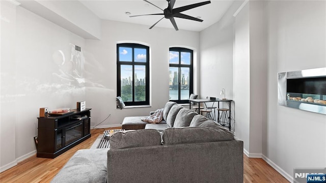 living room with ceiling fan and light hardwood / wood-style floors