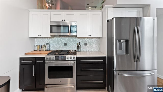 kitchen featuring white cabinetry, appliances with stainless steel finishes, and decorative backsplash