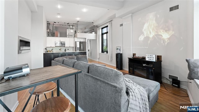 living room featuring wood-type flooring and a towering ceiling