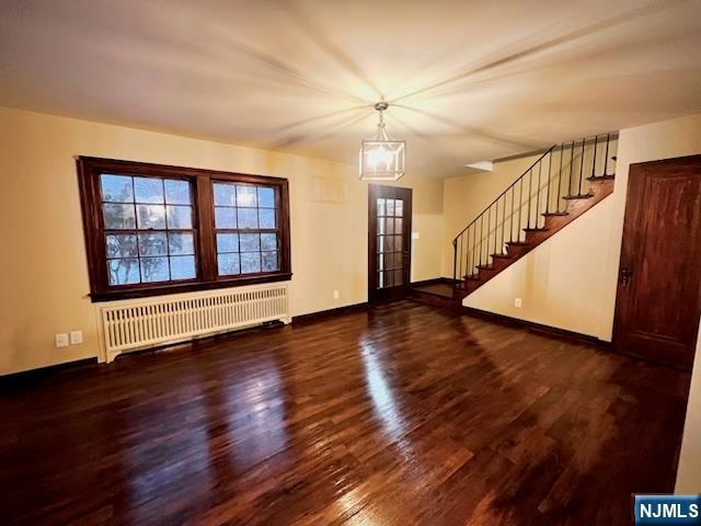 entrance foyer with radiator heating unit and dark hardwood / wood-style flooring