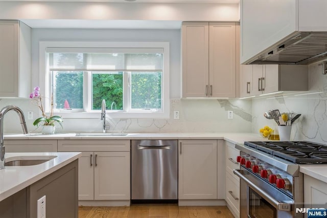 kitchen with stainless steel appliances, white cabinetry, sink, and tasteful backsplash