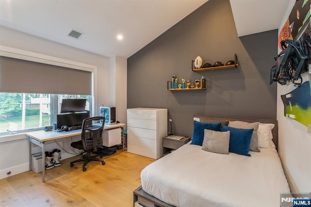 bedroom featuring lofted ceiling and light wood-type flooring