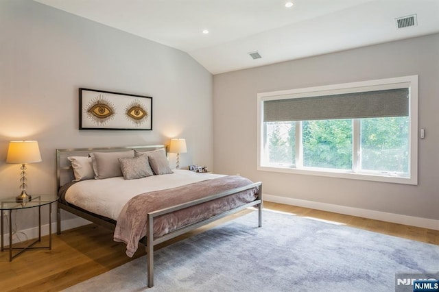 bedroom featuring vaulted ceiling and wood-type flooring