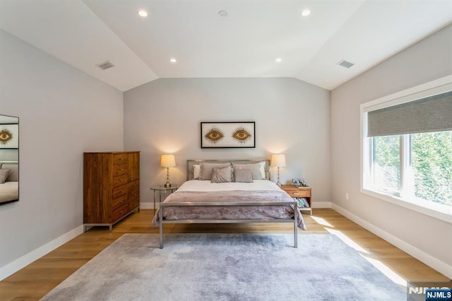 bedroom featuring lofted ceiling and light hardwood / wood-style flooring