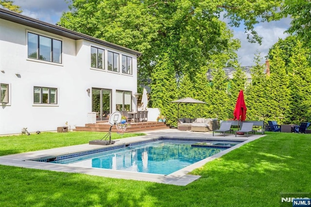 back of property with a pool side deck, an outdoor living space, and a yard