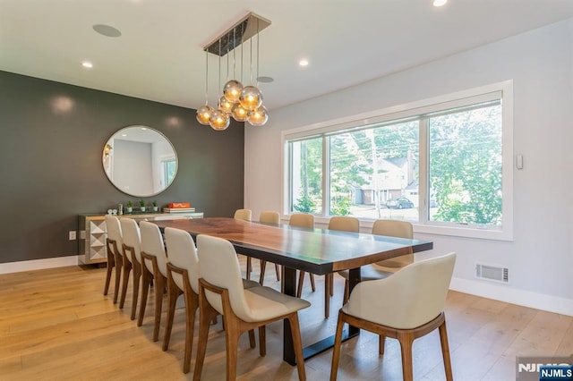 dining room featuring an inviting chandelier and light hardwood / wood-style flooring