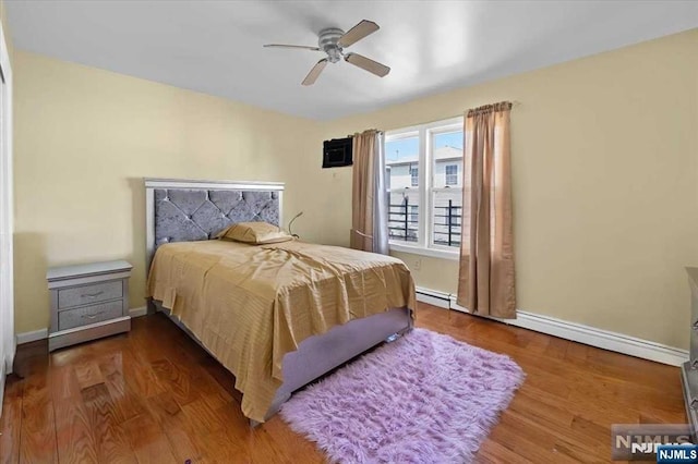 bedroom featuring ceiling fan, a baseboard radiator, and hardwood / wood-style floors