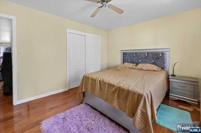 bedroom with dark wood-type flooring, ceiling fan, and a closet