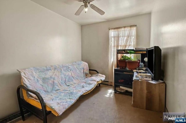 living area with ceiling fan, concrete floors, and baseboard heating