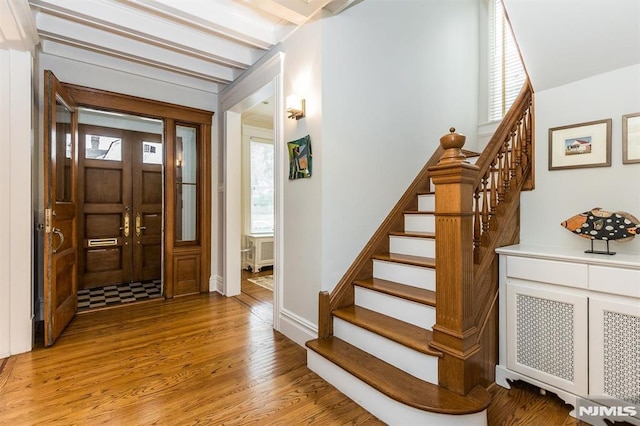 entrance foyer with beamed ceiling and light wood-type flooring