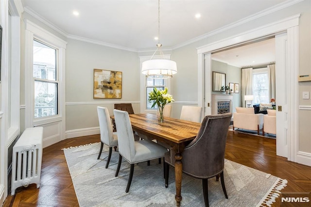 dining space with crown molding, radiator heating unit, and dark parquet floors