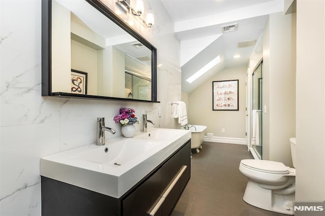 bathroom featuring vanity, a shower with shower door, vaulted ceiling with skylight, and toilet